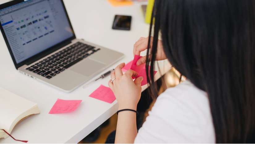 Woman writing things on post-it notes in an office