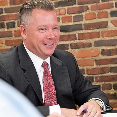 James McSweeney smiling during a meeting