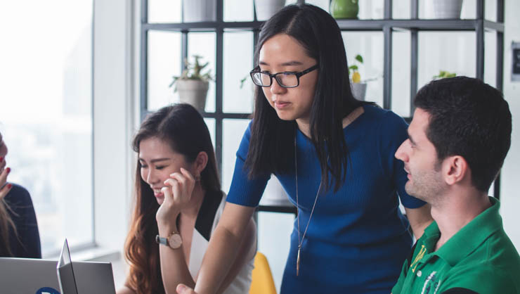 Woman showing co-workers something on the computer