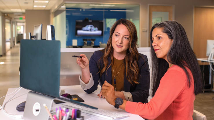 Woman helping other woman on the computer