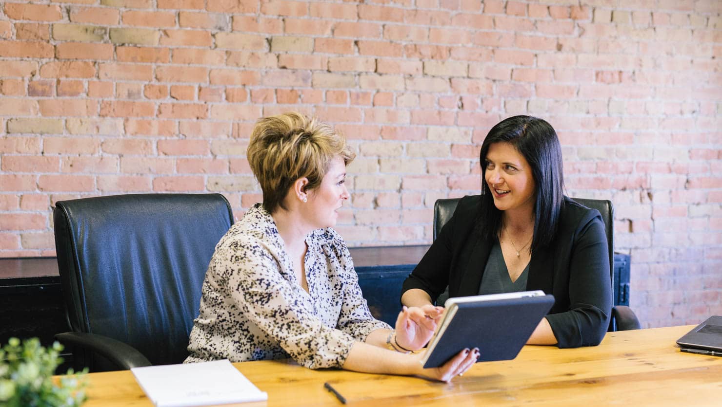 Two women discussing something at a conference table