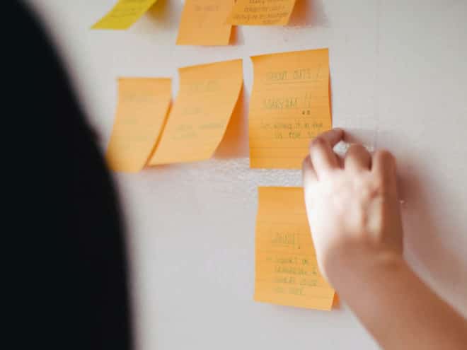 Person putting post-its on a board