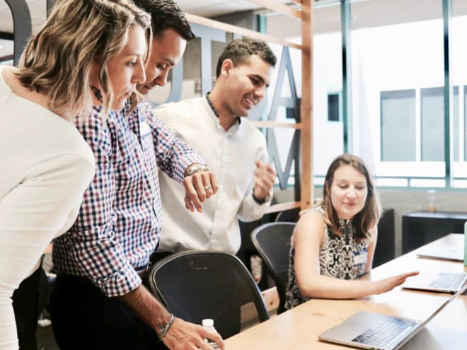 Co-workers huddled around a computer