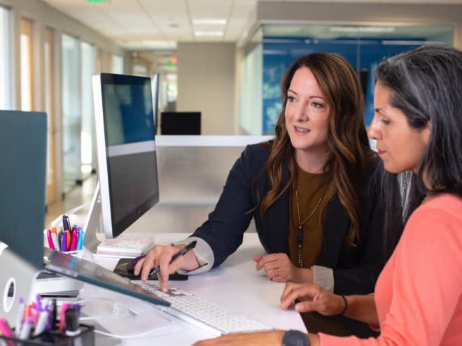 Woman helping another woman on the computer