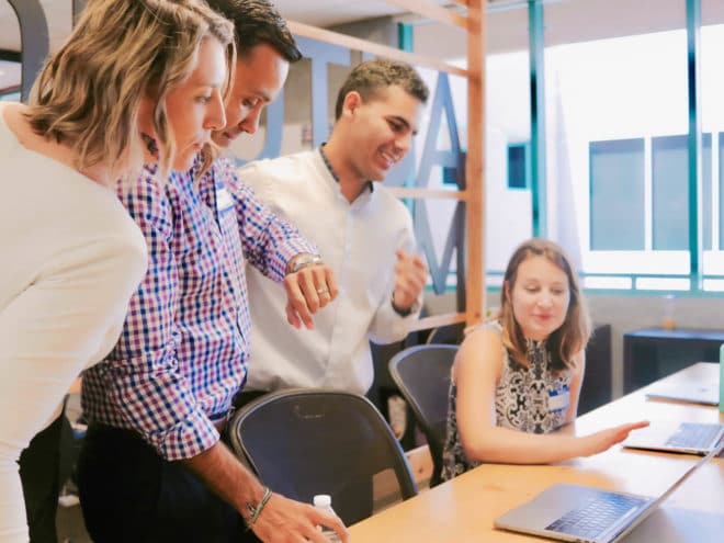 Co-workers huddled around a computer