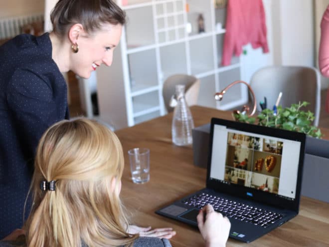 Woman helping other woman with something on the computer