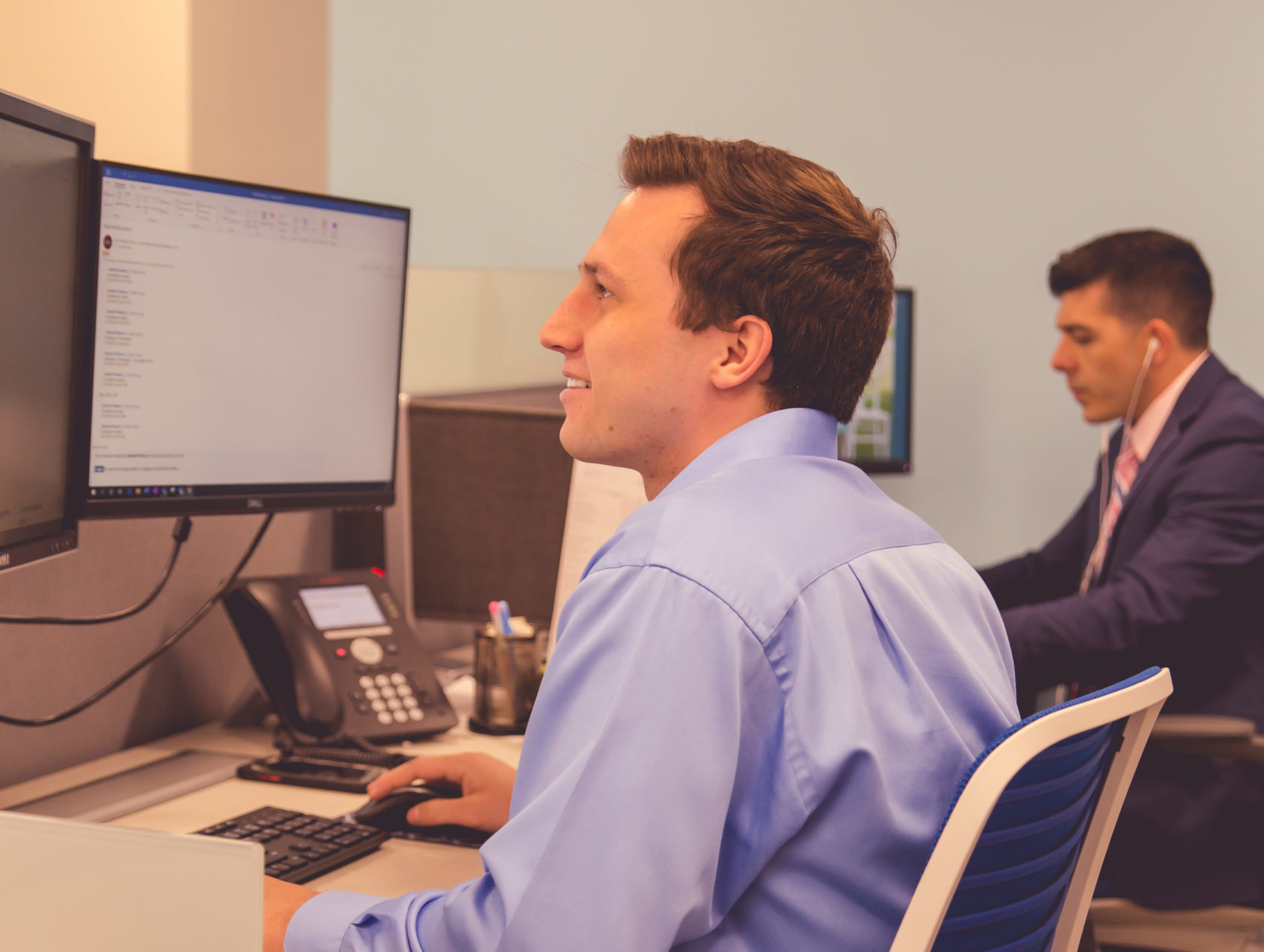 Two male CIP Group team members sitting at their desks