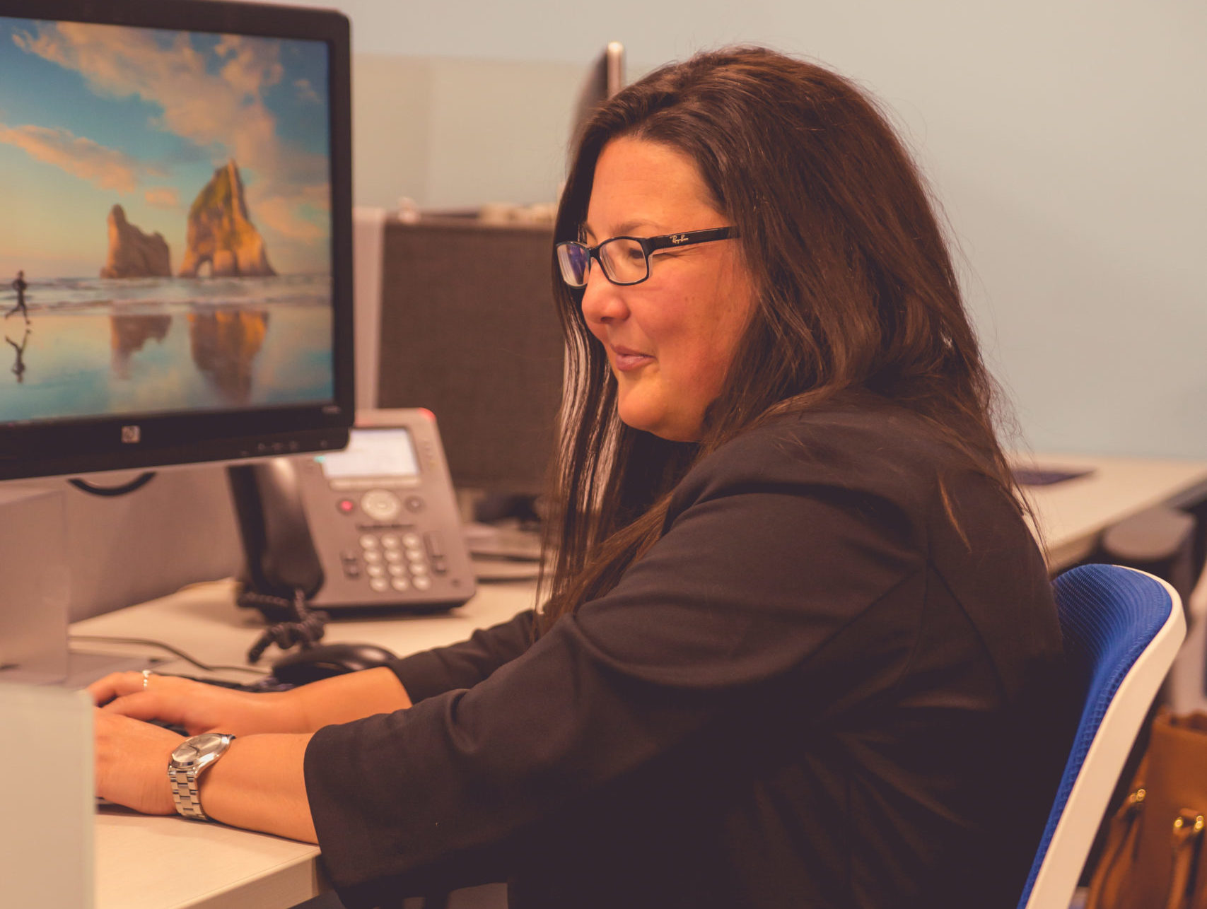 Female CIP Group team member sitting at her desk on the computer
