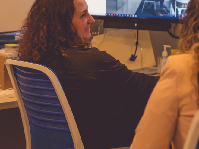 Two female CIP Group team members meeting at their desks